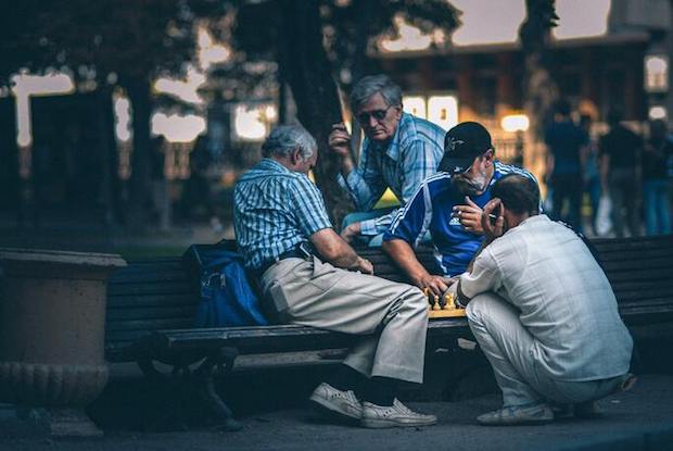 A group of older men play chess together